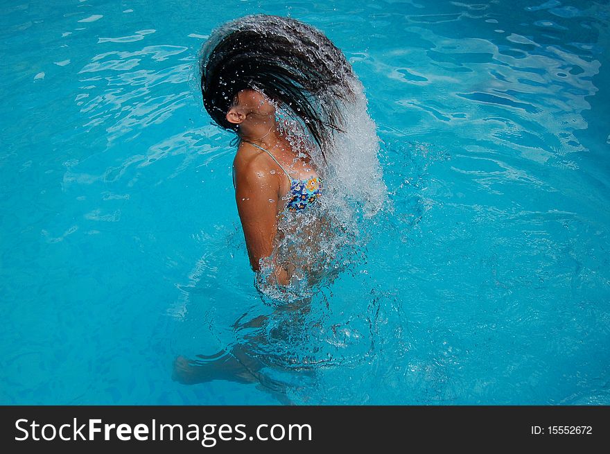 A young girl is having fun in a swimming pool