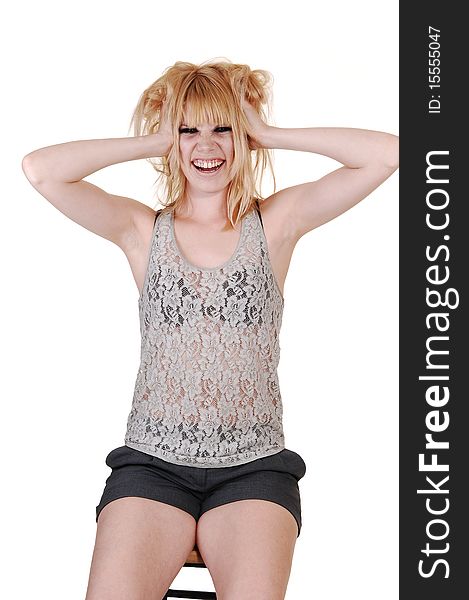 An blond greasy woman, sitting on a chair in the studio, in shorts and a lace top messing up her hair, for white background. An blond greasy woman, sitting on a chair in the studio, in shorts and a lace top messing up her hair, for white background.