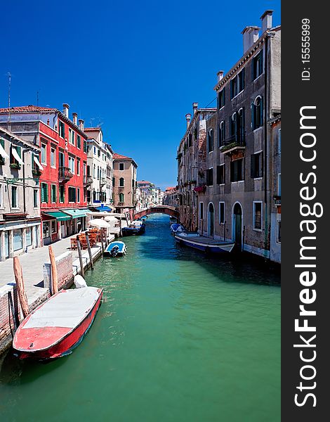 View of beautiful colored venice canal with bridge and houses standing in water