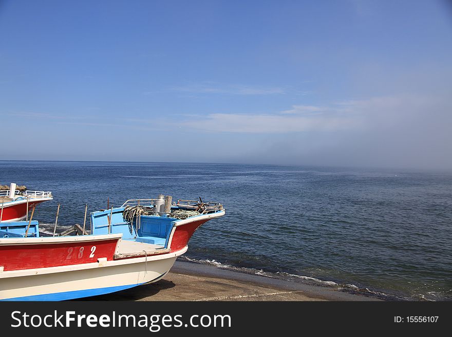 Fishing Boats on Shore on Clear Blue Sky Day