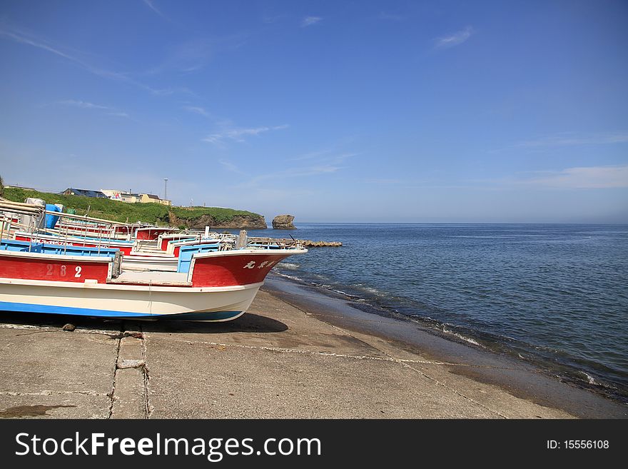 Fishing Boats On Shore On Clear Blue Sky Day