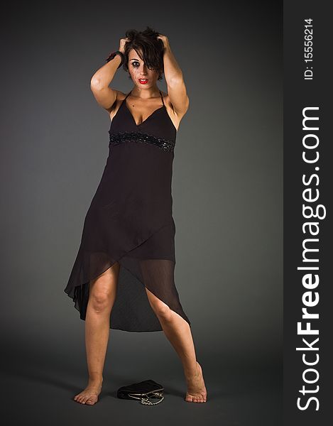 Tearful woman in black dress posing in studio
