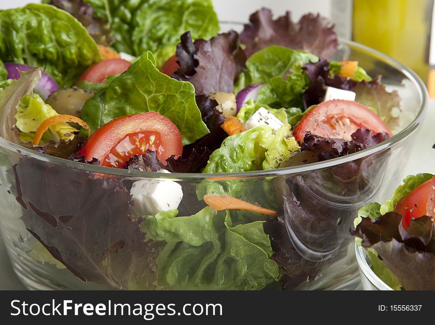 Glass serving bowl of fresh green salad. Glass serving bowl of fresh green salad.