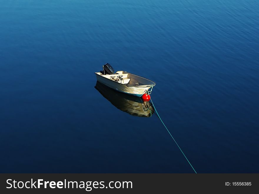 Single boat floating on the calm sea surface. Single boat floating on the calm sea surface