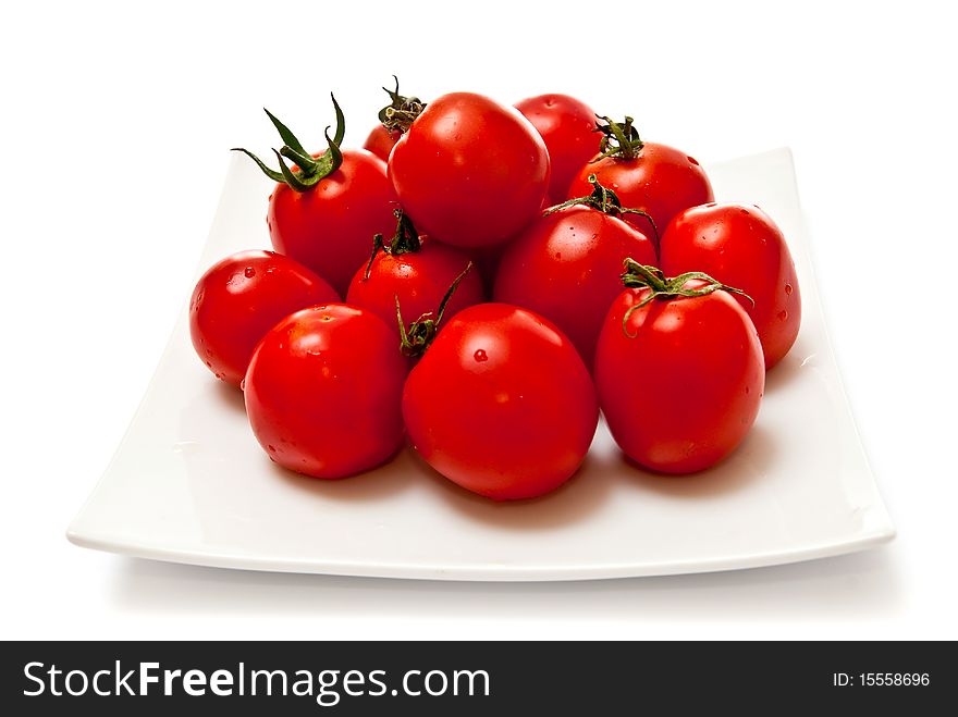 Fresh tomatoes on white plate. Isolated on white background