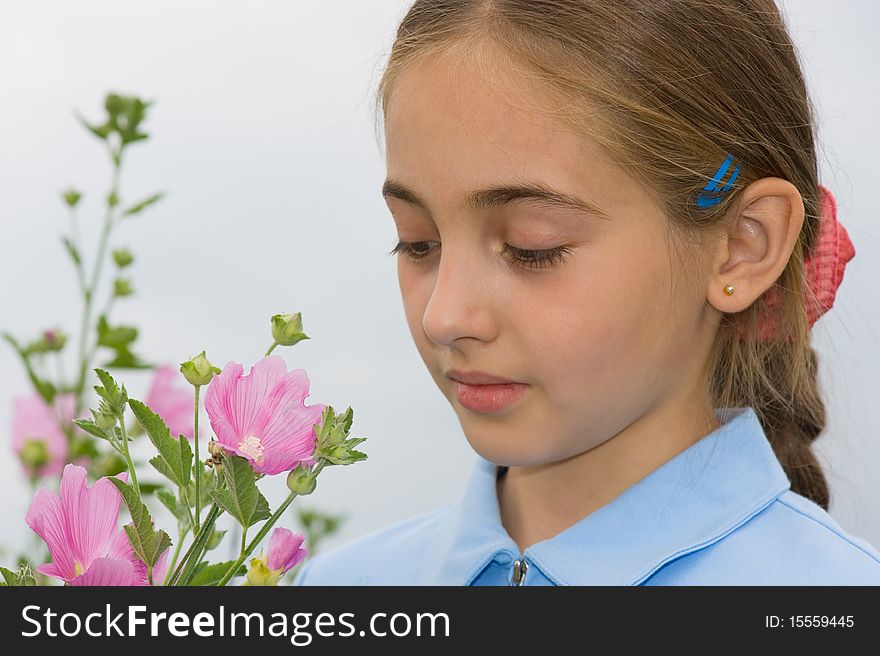 The girl looks at a field flower. The girl looks at a field flower