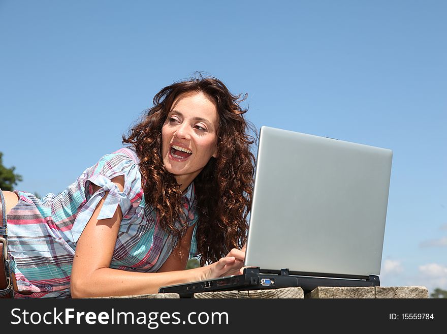 Woman using laptop computer on a pontoon. Woman using laptop computer on a pontoon