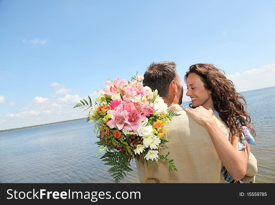 Man surprising woman with bunch of flowers. Man surprising woman with bunch of flowers