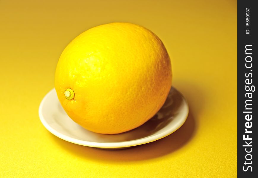 Lemon With A Small Plate On Yellow Background