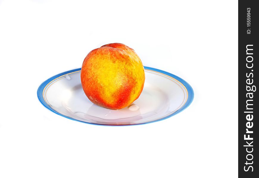 Tasty fresh peach on a plate on a white background with drops of water. Healthy food. Tasty fresh peach on a plate on a white background with drops of water. Healthy food