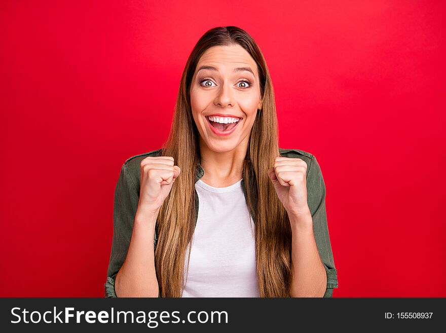 Photo of rejoicing enjoying nice cute woman showing her victory with fists while isolated with red background