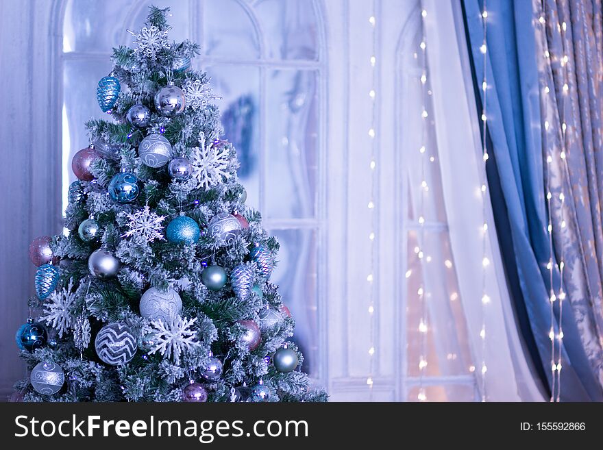 Christmas tree decorated with blue balls and snowflakes in blue tone