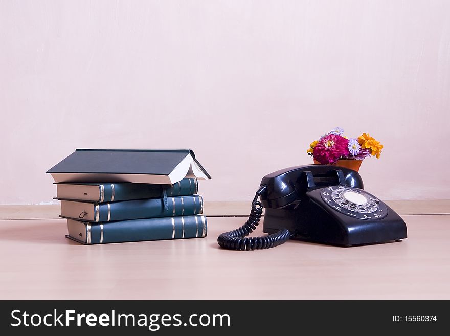 Stack Of Books With Vintage Telephone And Flowers