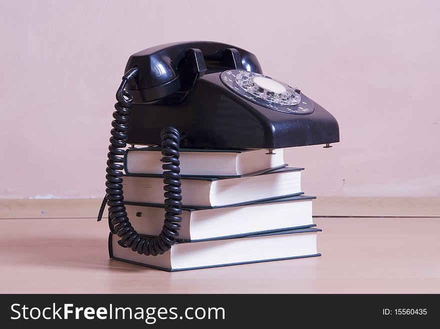 Stack Of Books With Vintage Telephone On Top