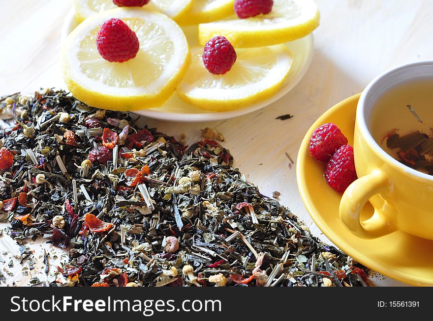 Cup with herbal tea, alongside lemon and dry tea