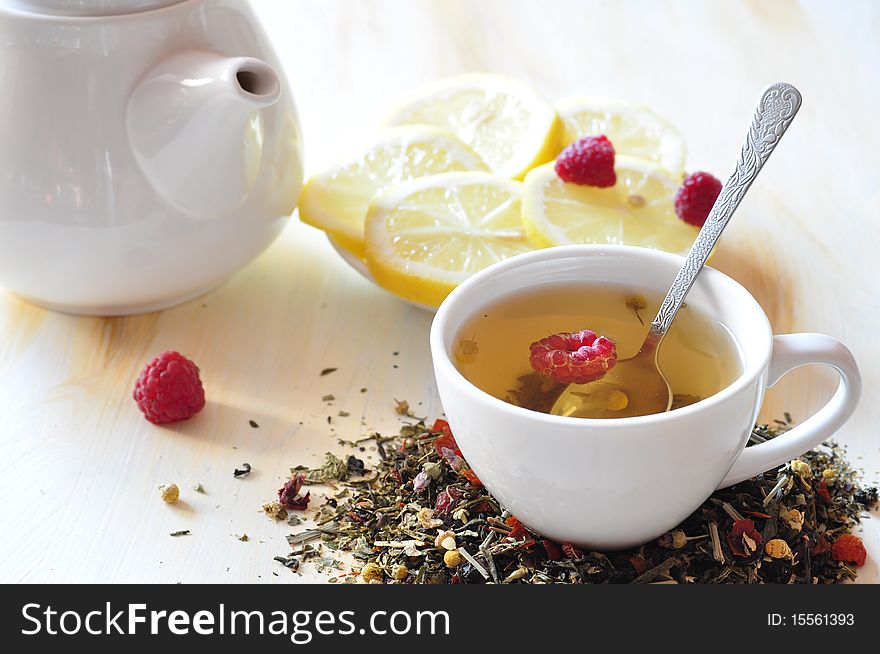 Cup with herbal tea, alongside lemon and dry tea