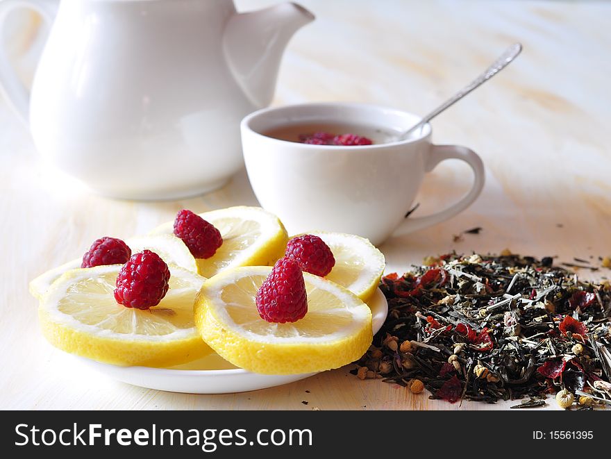 Cup with herbal tea, alongside lemon and dry tea