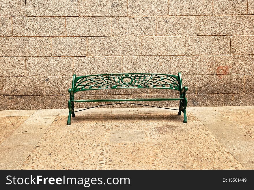Green bench in the street in Spain.