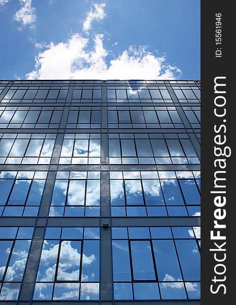 Modern glass building in perspective reflecting cloudy sky. Modern glass building in perspective reflecting cloudy sky