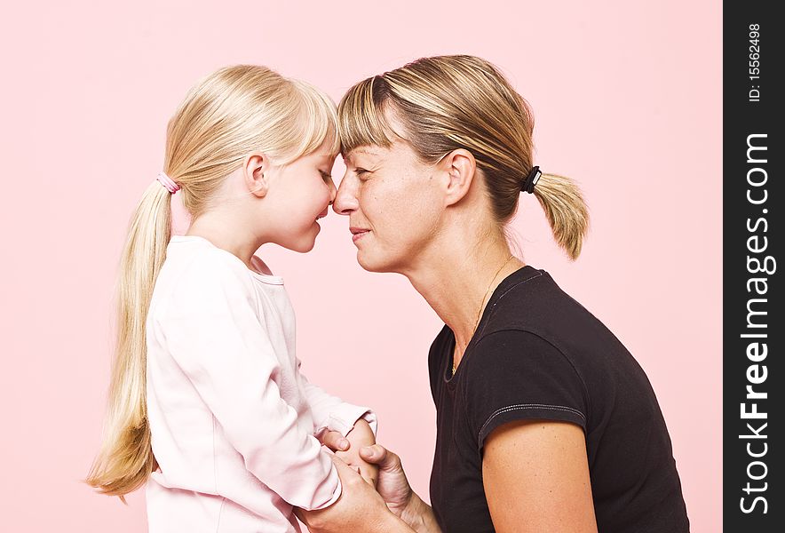 Mother and daughter on pink background