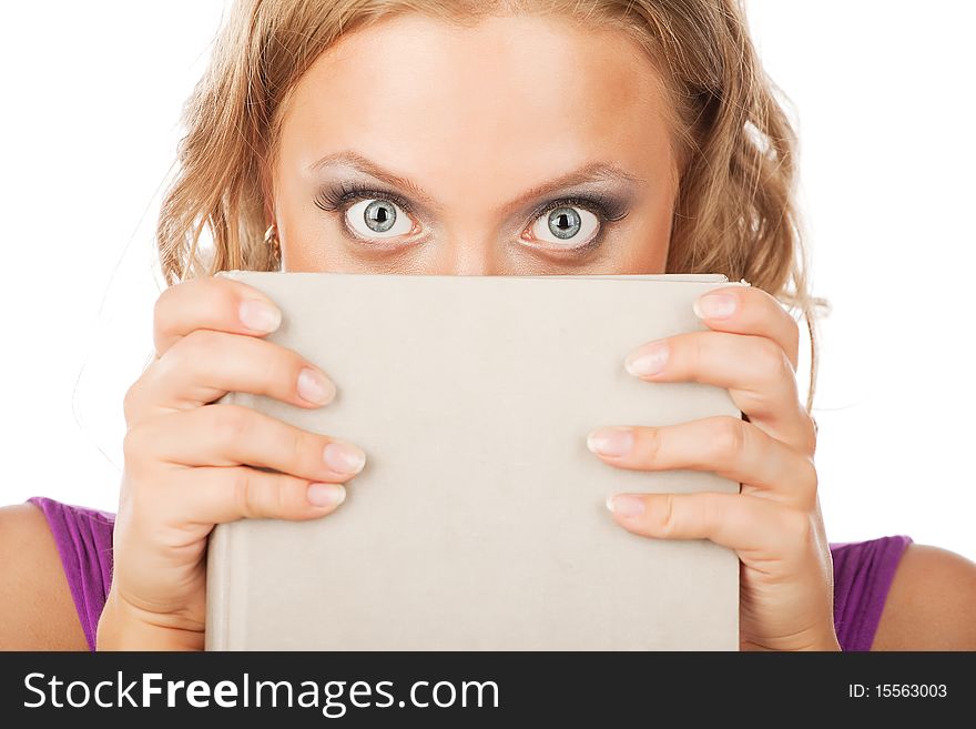 Pretty young woman looks up from her book isolated