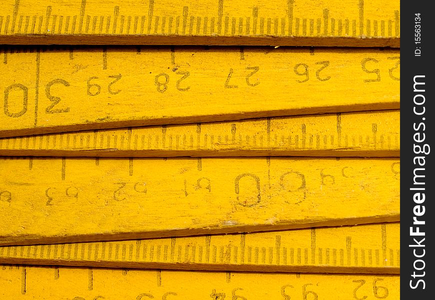 Old yellow wooden zigzag rule closeup background. Old yellow wooden zigzag rule closeup background.