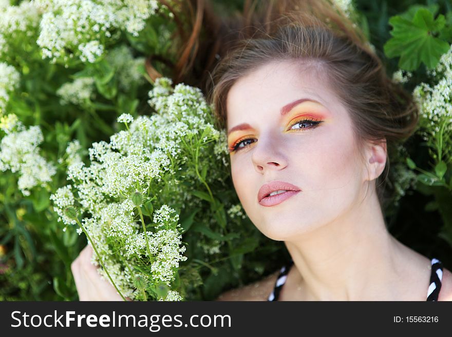 Young beautiful woman with bright makeup and white flowers. Young beautiful woman with bright makeup and white flowers
