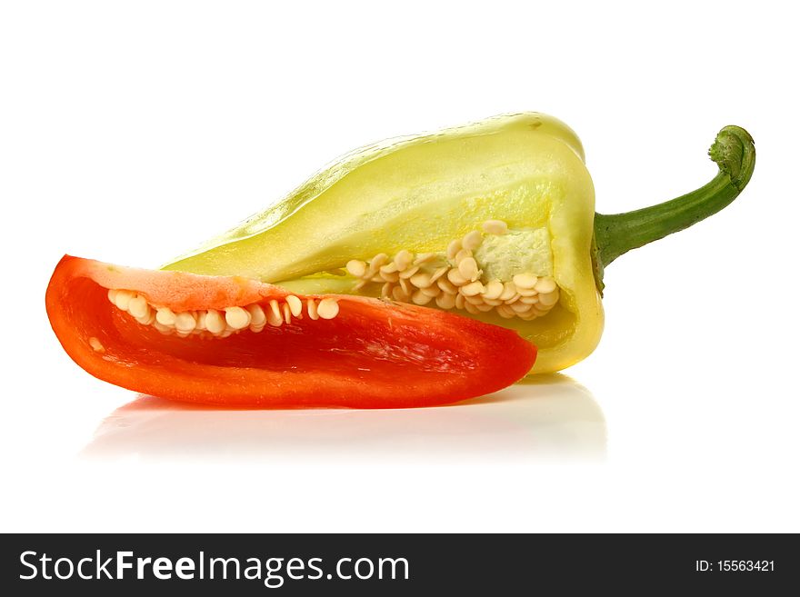 Red and yellow cut pepper and green leaf isolated on white background