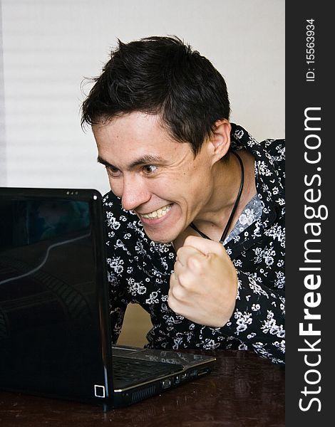 Man rejoices in what is happening on your computer monitor. Man rejoices in what is happening on your computer monitor