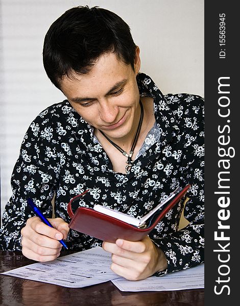 Man sitting at a table and fills forms. Man sitting at a table and fills forms