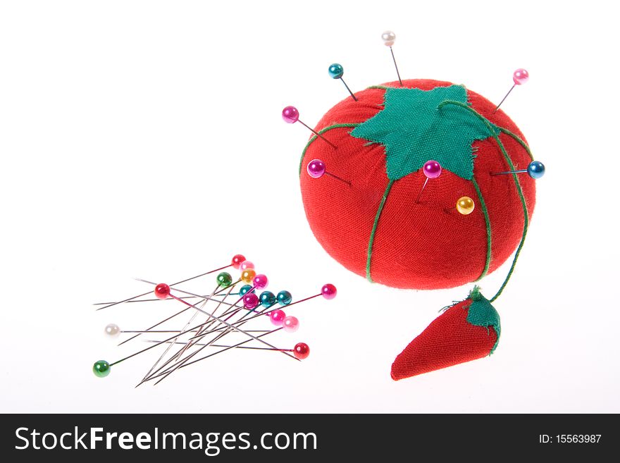 Tomato pin cushion & pins isolated on white
