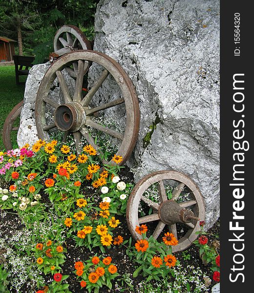 Ancient cart wheels used as decoration with flowers. Ancient cart wheels used as decoration with flowers