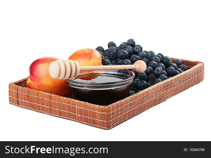 Peach, honey and blueberry in a wooden wattled tray.