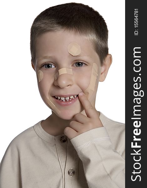 Young boy with band aids on face, studio shot