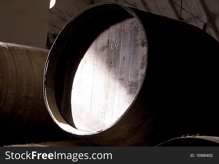 Closeup of a vine barrel inside a warehouse.
