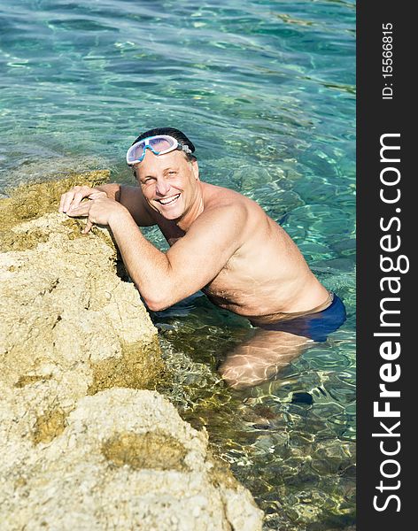 Color portrait photo of a happy laughing mature man having fun in the stunning blue turquoise sea. Color portrait photo of a happy laughing mature man having fun in the stunning blue turquoise sea.