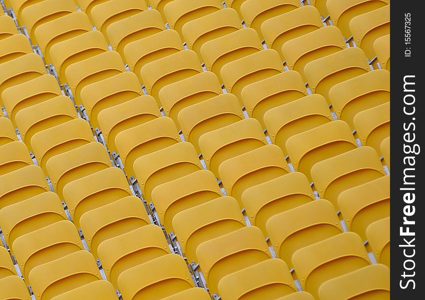 Rows of bright yellow empty folded spectator seats