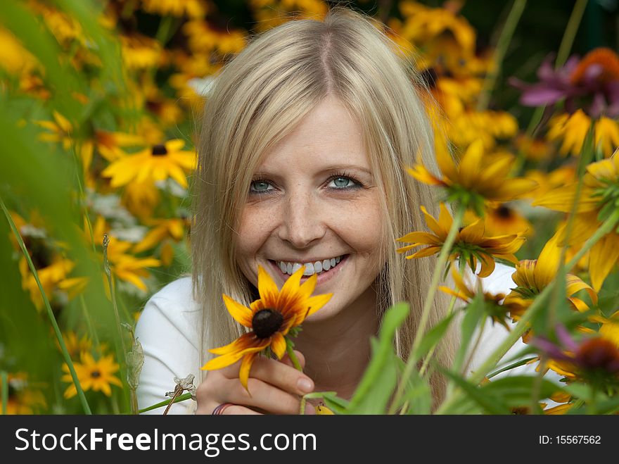 Young Woman Holding A Yellow Flower And Smiling