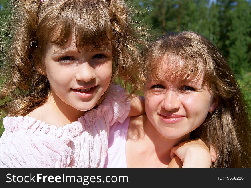 Portrait of the woman and the girl in the summer in park. Portrait of the woman and the girl in the summer in park