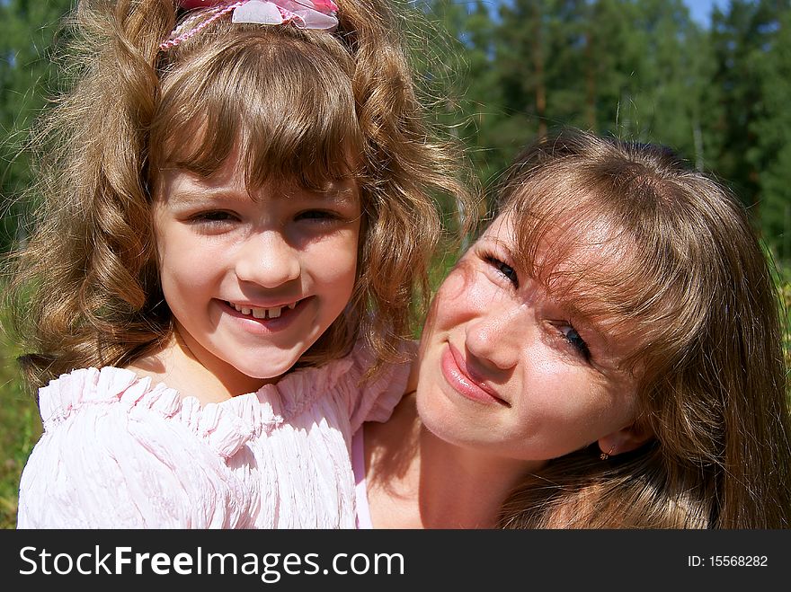 Portrait of the laughing woman and the girl in the summer in park. Portrait of the laughing woman and the girl in the summer in park