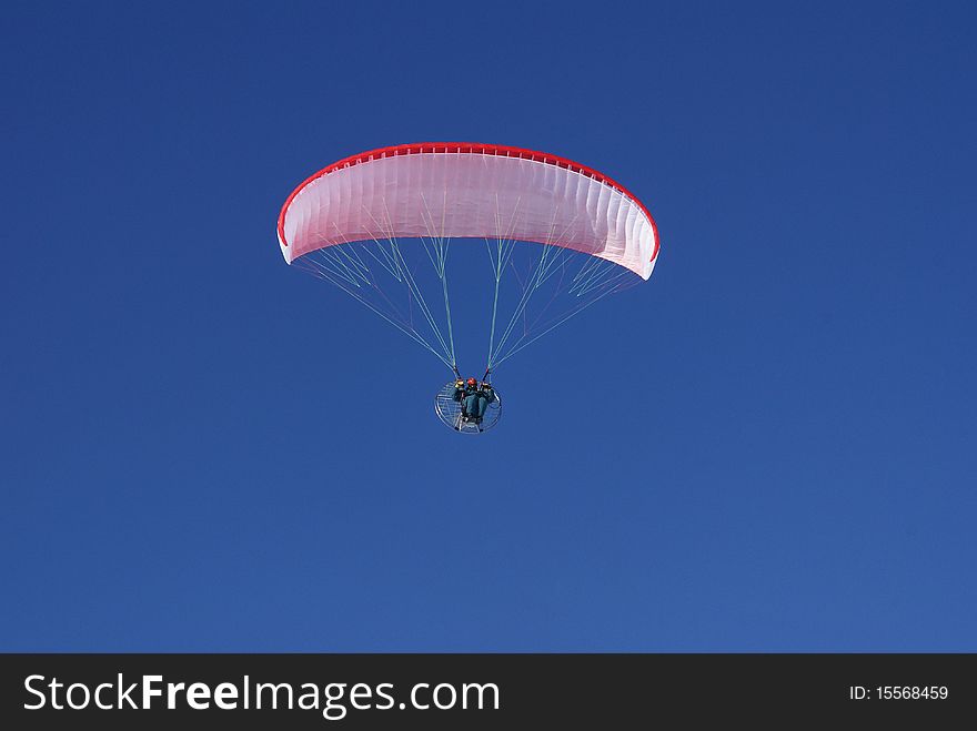 Paraglider flying in the blue sky