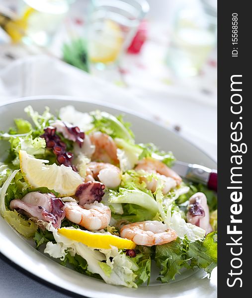 Green salad in a plate with shrimps and octopus