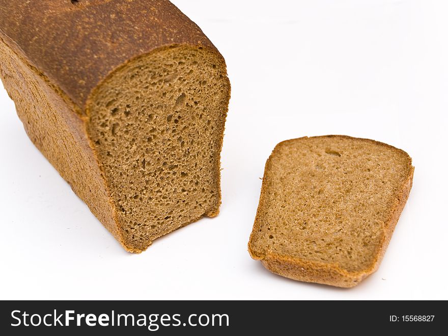 A loaf of rye bread and cut a chunk lying side by side, on a white background. A loaf of rye bread and cut a chunk lying side by side, on a white background