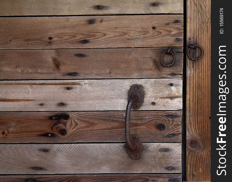 Old wooden doors with the rusty handle and loops