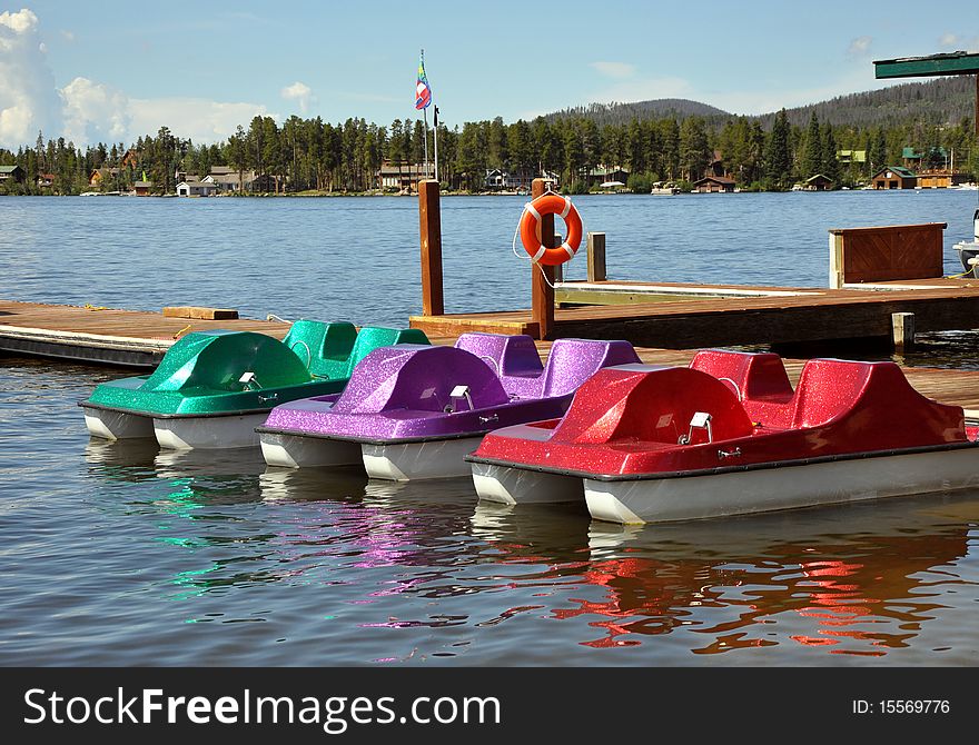 Three colorful paddleboats on a lake in Colorado