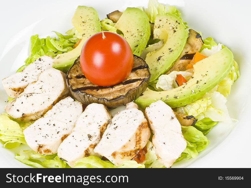 Close-up of grilled chicken breast salad with avocado, Boston lettuce and grilled vegetables.