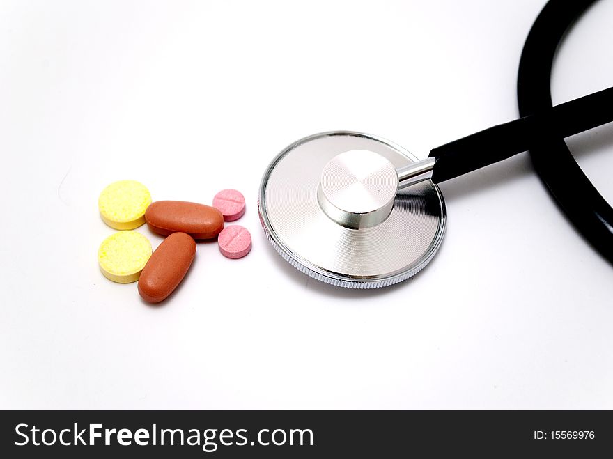 Stethoscope and pills isolated on white background