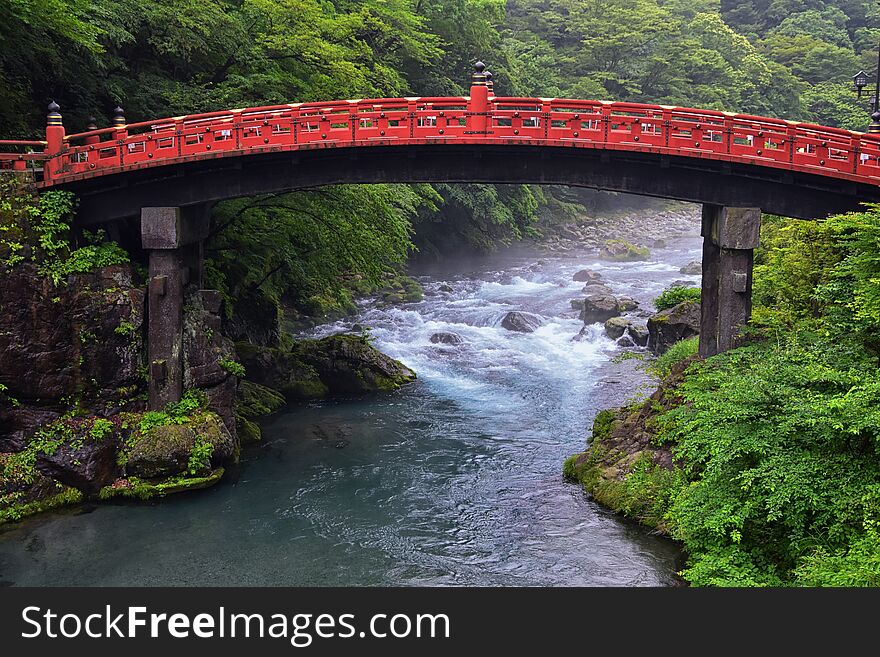 Shinkyo Bridge Over The Daiwa River In Nikko Outside Of Tokyo, Japan In Summer With Cloud Cover.