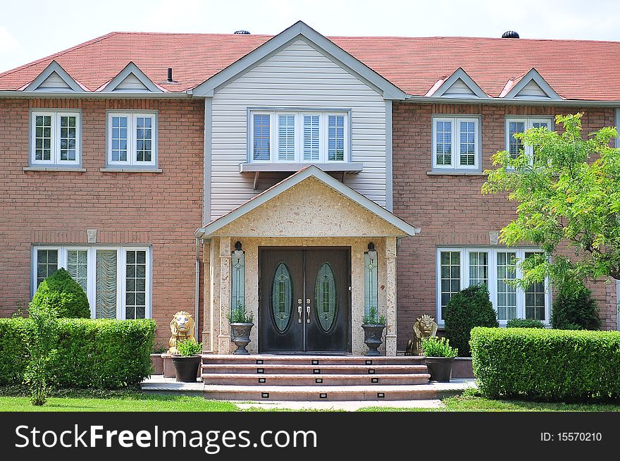 Beautiful luxury house with clear front view of entrance and well groomed garden