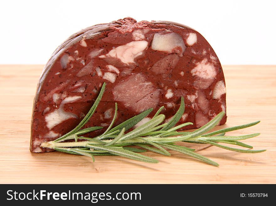 Traditional sausage: Headcheese on wooden background decorated with rosemary